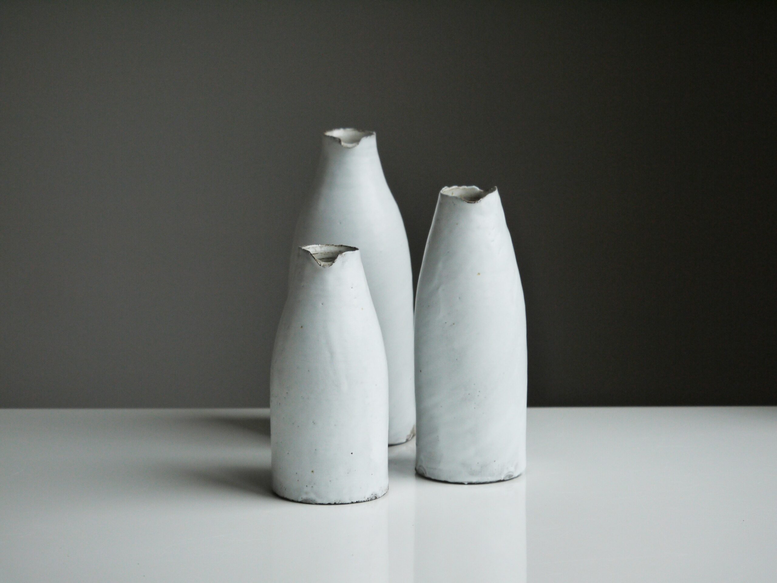 three white vases on table